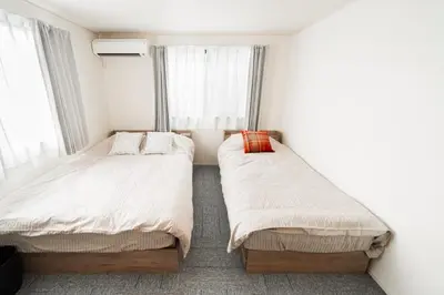 two beds in a small room with windows at \u5c0f\u6797 home in Tokyo