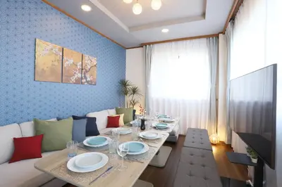 a dining room with a table and a couch at Stay Master Hotel in Tokyo