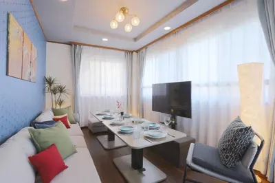 a living room with a table and a tv at Stay Master Hotel in Tokyo