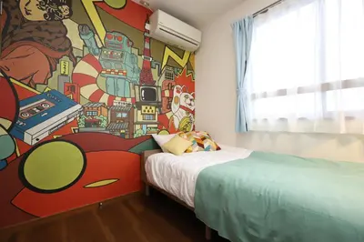 a bedroom with a superhero mural on the wall at Stay Master Hotel in Tokyo
