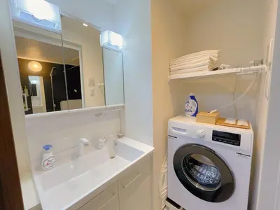 a bathroom with a washing machine and a mirror at Sakura Stay \u5343\u99c4\u6728 in Tokyo