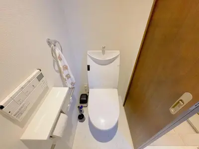 a bathroom with a white toilet and a wooden door at Sakura Stay \u5343\u99c4\u6728 in Tokyo