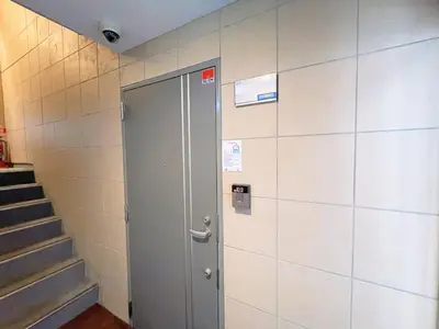 a gray door in a wall with a staircase at Sakura Stay \u5343\u99c4\u6728 in Tokyo
