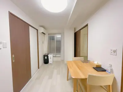 a room with a table and chairs and a hallway at Sakura Stay \u5343\u99c4\u6728 in Tokyo