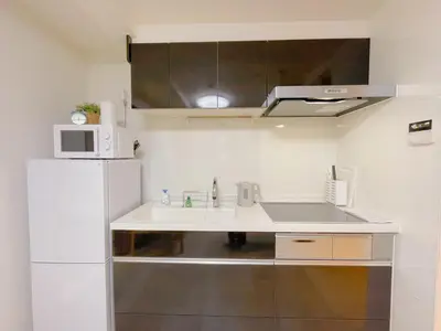 a kitchen with a sink and a white refrigerator at Sakura Stay \u5343\u99c4\u6728 in Tokyo