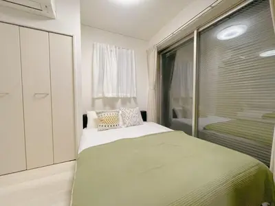 a bedroom with a large bed and a window at Sakura Stay \u5343\u99c4\u6728 in Tokyo