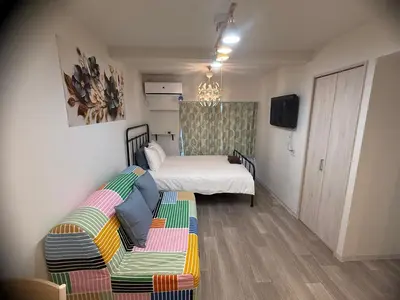 a small room with a bed and a couch at 5minutes from Shinjuku Shin-Okubo Station-k203 in Tokyo