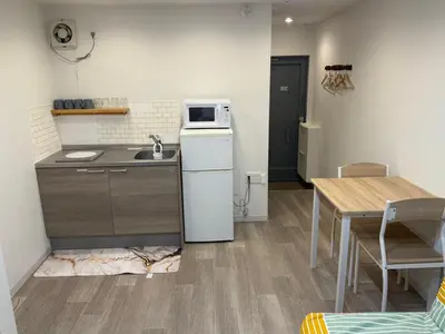 a kitchen with a sink and a refrigerator and a table at 5minutes from Shinjuku Shin-Okubo Station-k203 in Tokyo