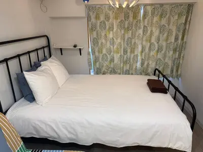 a bedroom with a bed with white sheets and a window at 5minutes from Shinjuku Shin-Okubo Station-k203 in Tokyo