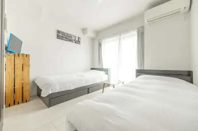a white bedroom with two beds and a window at \u677f\u6a4b\u533a yuga house\u99c5\u8fd1102 in Tokyo