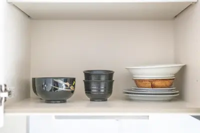 four bowls and plates sitting on a shelf at \u677f\u6a4b\u533a yuga house\u99c5\u8fd1102 in Tokyo