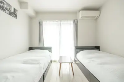 two twin beds in a room with a window at \u677f\u6a4b\u533a yuga house\u99c5\u8fd1102 in Tokyo