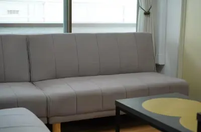 a couch in a living room with a table and a window at nagumobiru202 in Tokyo