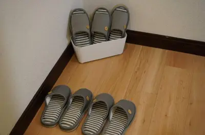 a row of pairs of shoes sitting on a wooden floor at nagumobiru202 in Tokyo