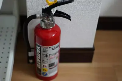 a red fire extinguisher is sitting on a table at nagumobiru202 in Tokyo