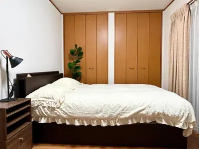 a bedroom with a bed with a wooden headboard at AiES\u65b0\u5c0f\u5ca9 \u65b0\u5c0f\u5ca9\u7ad9\u8d708\u5206 \u7e41\u534e\u5546\u5e97\u8857\u65c1 \u6700\u592712\u4eba \u76f4\u8fbe\u673a\u573a\u79cb\u53f6\u539f\u65b0\u5bbf \u65c5\u9986\u5185\u5e26\u514d\u8d39\u505c\u8f66\u573a\u5ead\u9662\u9732\u53f0 \u90bb\u516c\u56ed in Tokyo