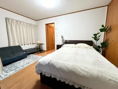 a bedroom with a large white bed and a window at AiES\u65b0\u5c0f\u5ca9 \u65b0\u5c0f\u5ca9\u7ad9\u8d708\u5206 \u7e41\u534e\u5546\u5e97\u8857\u65c1 \u6700\u592712\u4eba \u76f4\u8fbe\u673a\u573a\u79cb\u53f6\u539f\u65b0\u5bbf \u65c5\u9986\u5185\u5e26\u514d\u8d39\u505c\u8f66\u573a\u5ead\u9662\u9732\u53f0 \u90bb\u516c\u56ed in Tokyo