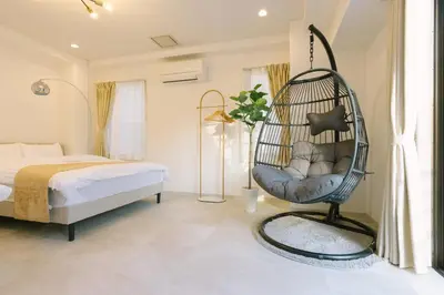 a bedroom with a swing chair next to a bed at Penthouse, 8min walk to Shibuya Sta in Tokyo