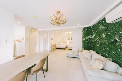 a living room with a couch and a green wall at Penthouse, 8min walk to Shibuya Sta in Tokyo