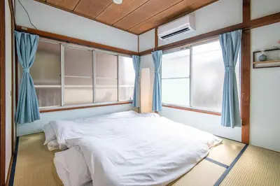 a bed in a room with two windows at 25\u5e74\u30d5\u30eb\u30ea\u30ce\u30d9 7\u6708\u65b0\u30aa\u30fc\u30d7\u30f3 \u6700\u59278\u4eba \u8cb8\u5207 \u845b\u897f\u99c5\u5f92\u6b6912\u5206 3\u30d9\u30c3\u30c9\u30eb\u30fc\u30e0 46\u5e73\u7c73\u3067\u3054\u5bb6\u65cf\u6700\u9069 in Tokyo