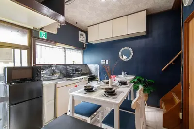 a kitchen with a white table and a blue wall at 25\u5e74\u30d5\u30eb\u30ea\u30ce\u30d9 7\u6708\u65b0\u30aa\u30fc\u30d7\u30f3 \u6700\u59278\u4eba \u8cb8\u5207 \u845b\u897f\u99c5\u5f92\u6b6912\u5206 3\u30d9\u30c3\u30c9\u30eb\u30fc\u30e0 46\u5e73\u7c73\u3067\u3054\u5bb6\u65cf\u6700\u9069 in Tokyo