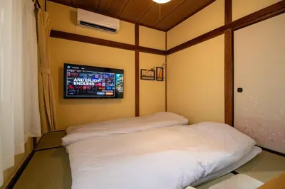 a room with two beds and a tv on the wall at 25\u5e74\u30d5\u30eb\u30ea\u30ce\u30d9 7\u6708\u65b0\u30aa\u30fc\u30d7\u30f3 \u6700\u59278\u4eba \u8cb8\u5207 \u845b\u897f\u99c5\u5f92\u6b6912\u5206 3\u30d9\u30c3\u30c9\u30eb\u30fc\u30e0 46\u5e73\u7c73\u3067\u3054\u5bb6\u65cf\u6700\u9069 in Tokyo