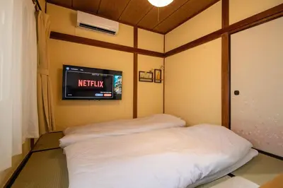 a room with two beds and a tv on the wall at 25\u5e74\u30d5\u30eb\u30ea\u30ce\u30d9 7\u6708\u65b0\u30aa\u30fc\u30d7\u30f3 \u6700\u59278\u4eba \u8cb8\u5207 \u845b\u897f\u99c5\u5f92\u6b6912\u5206 3\u30d9\u30c3\u30c9\u30eb\u30fc\u30e0 46\u5e73\u7c73\u3067\u3054\u5bb6\u65cf\u6700\u9069 in Tokyo