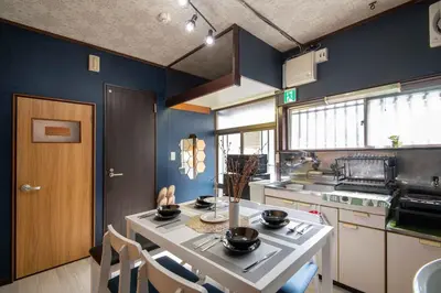 a kitchen with blue walls and a table with chairs at 25\u5e74\u30d5\u30eb\u30ea\u30ce\u30d9 7\u6708\u65b0\u30aa\u30fc\u30d7\u30f3 \u6700\u59278\u4eba \u8cb8\u5207 \u845b\u897f\u99c5\u5f92\u6b6912\u5206 3\u30d9\u30c3\u30c9\u30eb\u30fc\u30e0 46\u5e73\u7c73\u3067\u3054\u5bb6\u65cf\u6700\u9069 in Tokyo