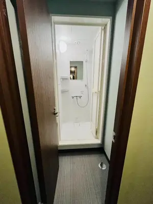 a bathroom with a shower and a toilet in a room at Meguro Midori Hotel in Tokyo