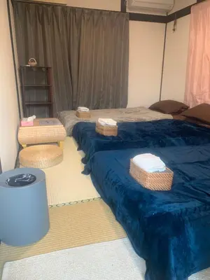 two beds in a room with blue sheets and baskets at \u4ec1\u4fe1\u5c0f\u5c4b in Tokyo