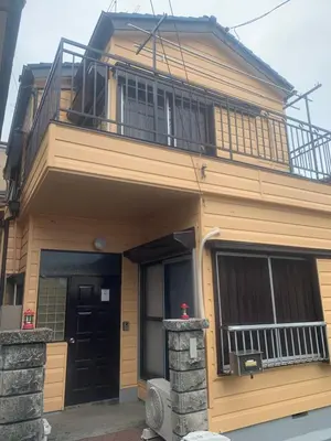 a house with a balcony on top of it at \u4ec1\u4fe1\u5c0f\u5c4b in Tokyo
