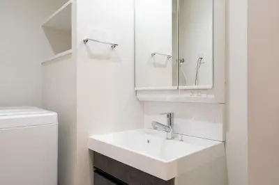 a white bathroom with a sink and a mirror at Daffitto\u672c\u6240\u543e\u59bb\u6a4b in Tokyo