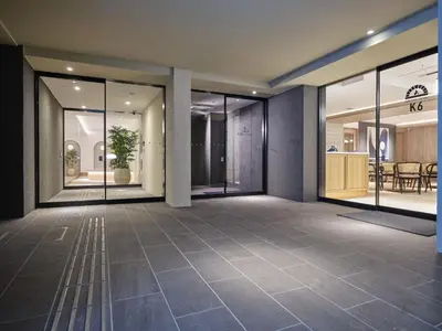 an empty lobby with glass doors and a table at Premium hotel MONday MAIHAMA View 1 in Tokyo