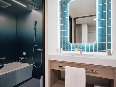 a bathroom with a sink and a tub and a mirror at Premium hotel MONday MAIHAMA View 1 in Tokyo