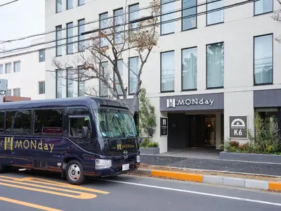 a blue bus parked in front of a building at Premium hotel MONday MAIHAMA View 1 in Tokyo