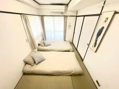 two beds in a small room with a window at \u6c5f\u5143\u6d45\u8349\u6c11\u6cca in Tokyo