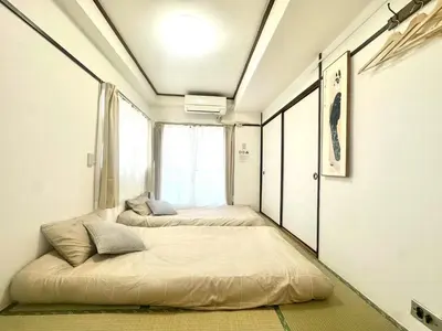 a bedroom with two beds and a window at \u6c5f\u5143\u6d45\u8349\u6c11\u6cca in Tokyo