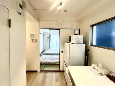 a small room with a refrigerator and a bed at \u6c5f\u5143\u6d45\u8349\u6c11\u6cca in Tokyo