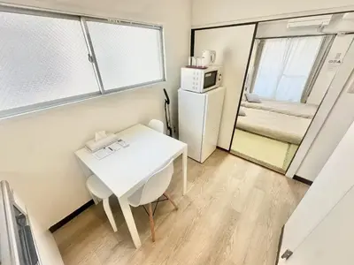 a small room with a white table and a refrigerator at \u6c5f\u5143\u6d45\u8349\u6c11\u6cca in Tokyo