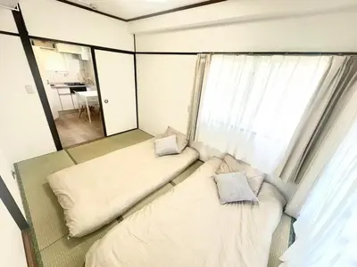 two beds in a small room with a window at \u6c5f\u5143\u6d45\u8349\u6c11\u6cca in Tokyo