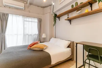a bedroom with a bed and a desk and a window at Private Apartment HOTEL Ceres Kamiikebukuro 301 in Tokyo