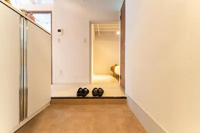 a hallway with two pairs of shoes on a floor at Private Apartment HOTEL Ceres Kamiikebukuro 301 in Tokyo