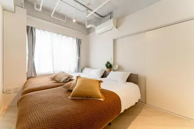 a bedroom with two beds and a large window at Private Apartment HOTEL Ceres Kamiikebukuro 301 in Tokyo