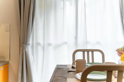 a table with two chairs next to a window at Private Apartment HOTEL Ceres Kamiikebukuro 301 in Tokyo