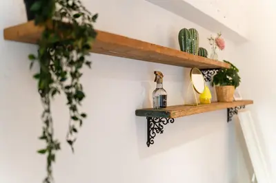 a wooden shelf on a wall with plants on it at Private Apartment HOTEL Ceres Kamiikebukuro 301 in Tokyo