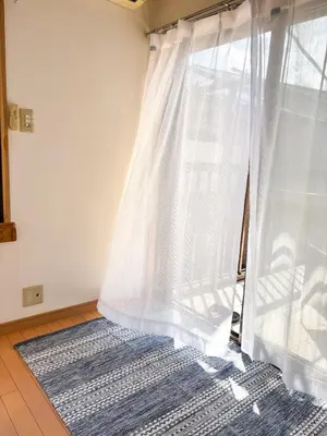 a room with a window with a curtain and a rug at \u30b2\u30b9\u30c8\u30cf\u30a6\u30b9\u967d\u3060\u307e\u308a\u306e\u3046\u305f\u305f\u306d\u3053 \u6708\u3068\u592a\u967d in Wada