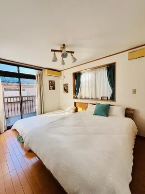 a large white bed in a room with a window at \u30b2\u30b9\u30c8\u30cf\u30a6\u30b9\u967d\u3060\u307e\u308a\u306e\u3046\u305f\u305f\u306d\u3053 \u6708\u3068\u592a\u967d in Wada
