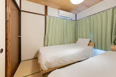 two beds in a small room with a window at Higashi-Ueno 3 in Tokyo