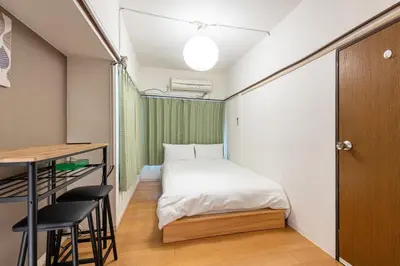 a small room with a bed and a table and chairs at Higashi-Ueno 3 in Tokyo