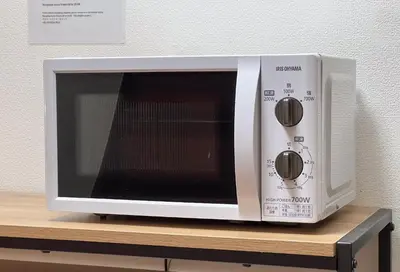a white microwave oven sitting on a wooden shelf at Higashi-Ueno 3 in Tokyo
